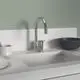 Chromene Küchenarmatur mit geradem Auslauf, montiert auf einer hellen Arbeitsfläche. Im Hintergrund eine weiße Schale und ein schwarzer Teller. Ideal Standard Produktdesign sichtbar.